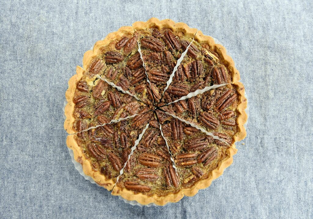 Photograph of a pecan pie divided in eighths.